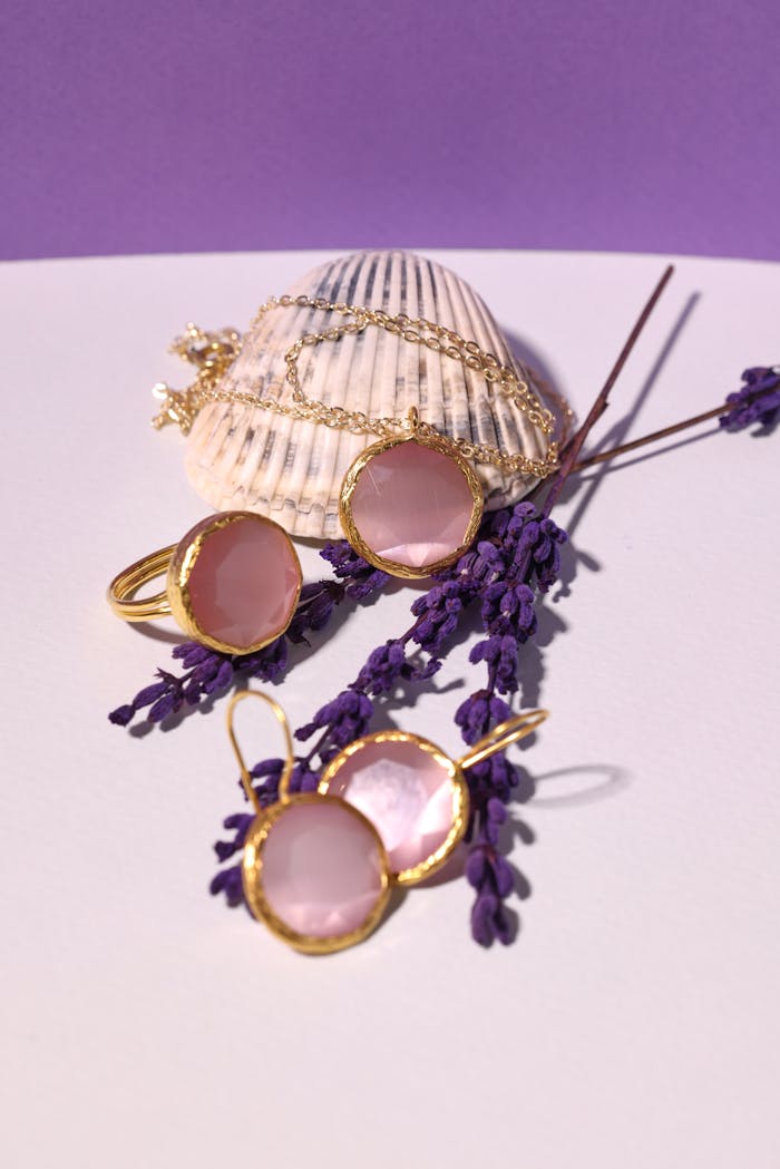 Mastering the First Impression: Your intriguing post title goes here Pink gemstone jewelry with shell on a purple background, sprinkled with lavender for a chic look.